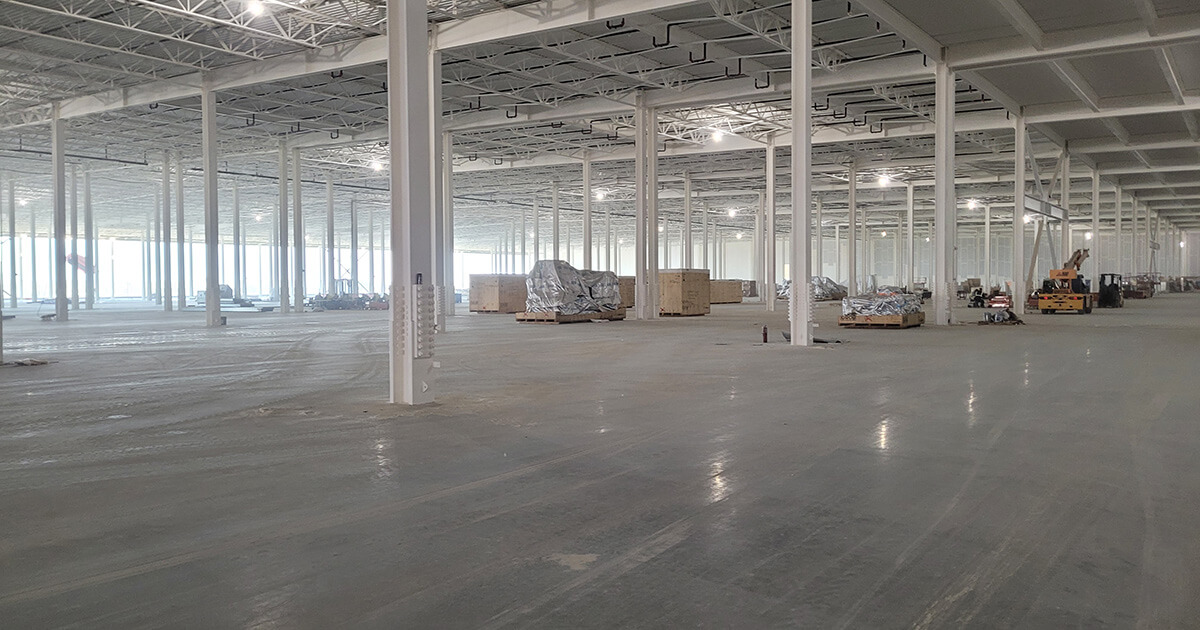 Intumescent passive fire protection is visible on structural steel in the massive EV manufacturing facility in Austin.