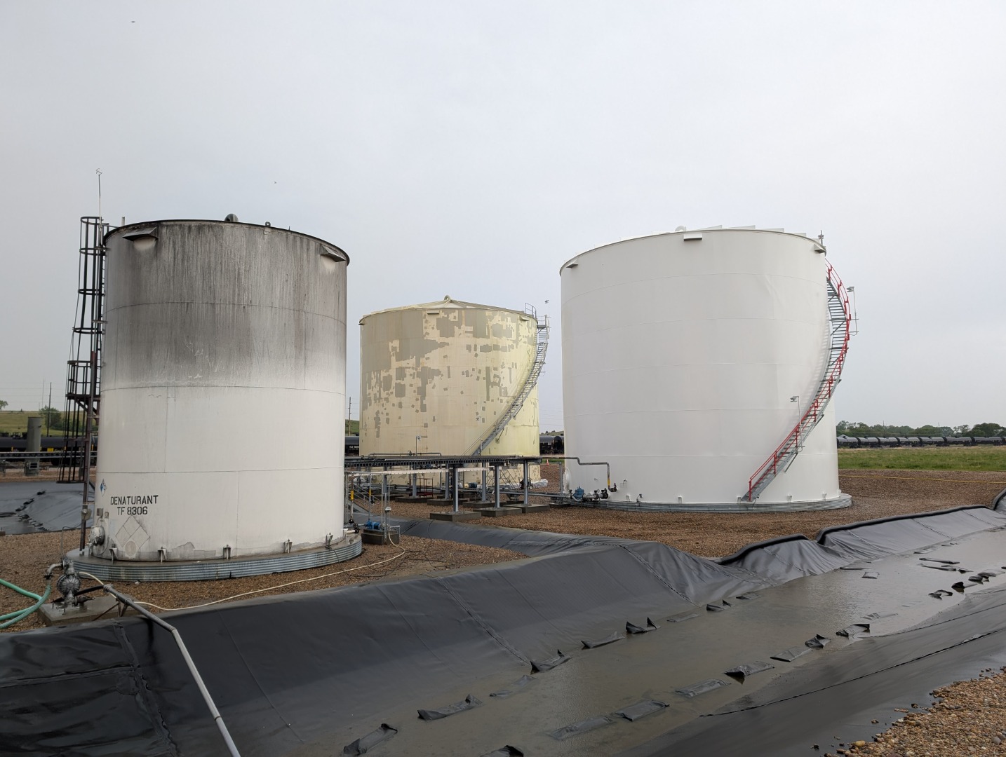 Three of the five tanks in Green America Biofuels’ tank farm are seen at various stages of the project. At left, a denaturant tank awaits cleaning. At center, a storage tank is seen following a thorough surface cleaning and application of Rustbond. At right, a storage tank newly coated in Carboxane 2100 BR.