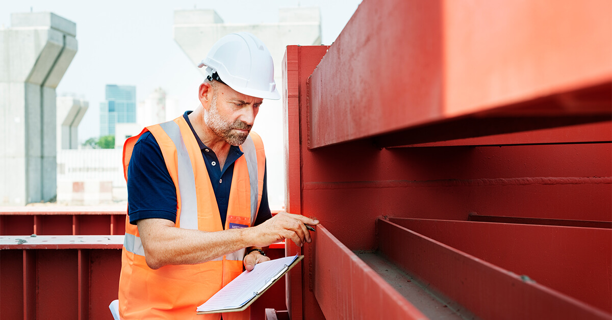 A coating inspector examines a recently coated piece of steel.